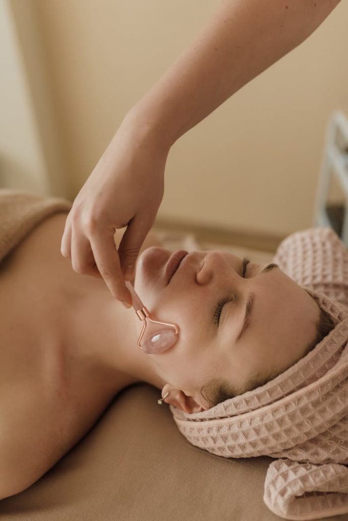 Woman enjoying a relaxing face roller massage as part of her skincare routine.